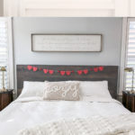 pom-pom garland on a mantel and red heart doily garland on a headboard.